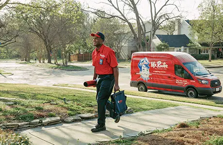 Mr. Rooter Residential Plumber walking up to a house