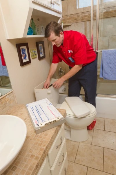 A plumber from Mr. Rooter Plumbing inspecting a toilet tank after completing toilet installation in Mississauga, ON.