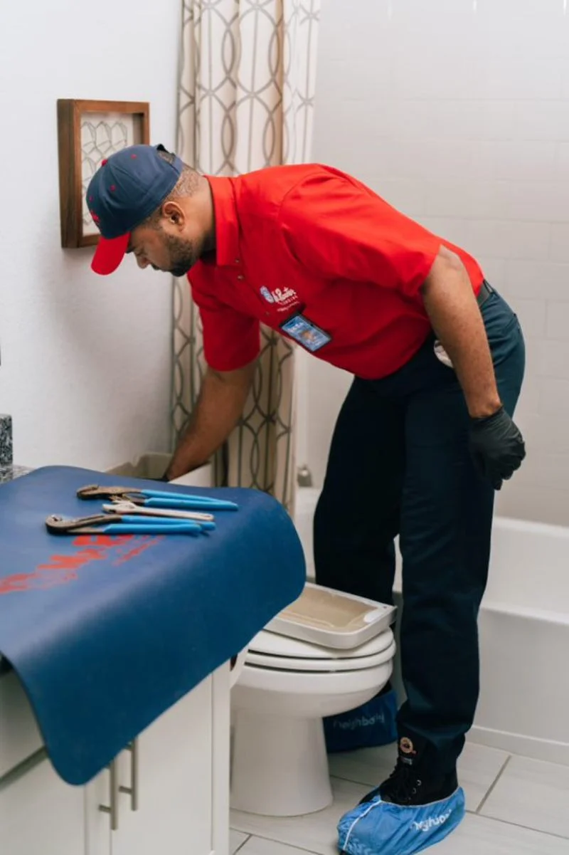 Mr Rooter plumber inspecting a toilet tank as a part of plumbing inspection