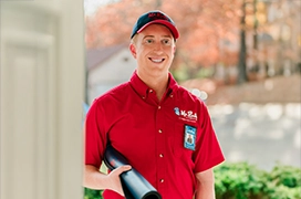 Smiling Mr. Rooter professional at a customer's front door.