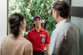 Mr. Rooter professional standing a customer's front door.