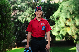 Mr. Rooter technician standing outside against a background of greenery.