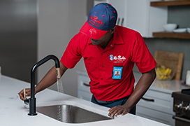 Mr. Rooter professional fixing a faucet.