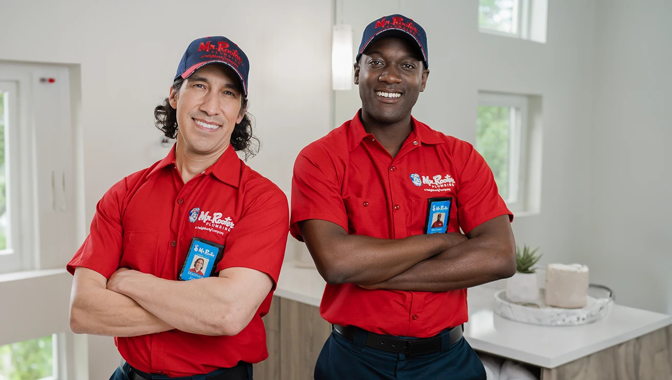 Two Mr. Rooter technicians posing with their arms crossed.