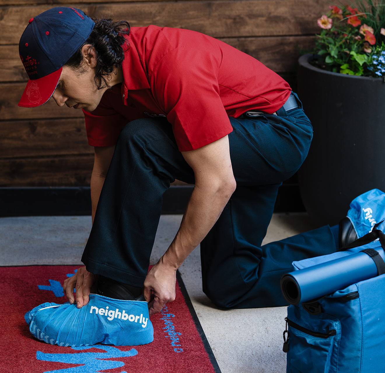 Mr. Rooter technician applying covers to his shoes before entering a home.