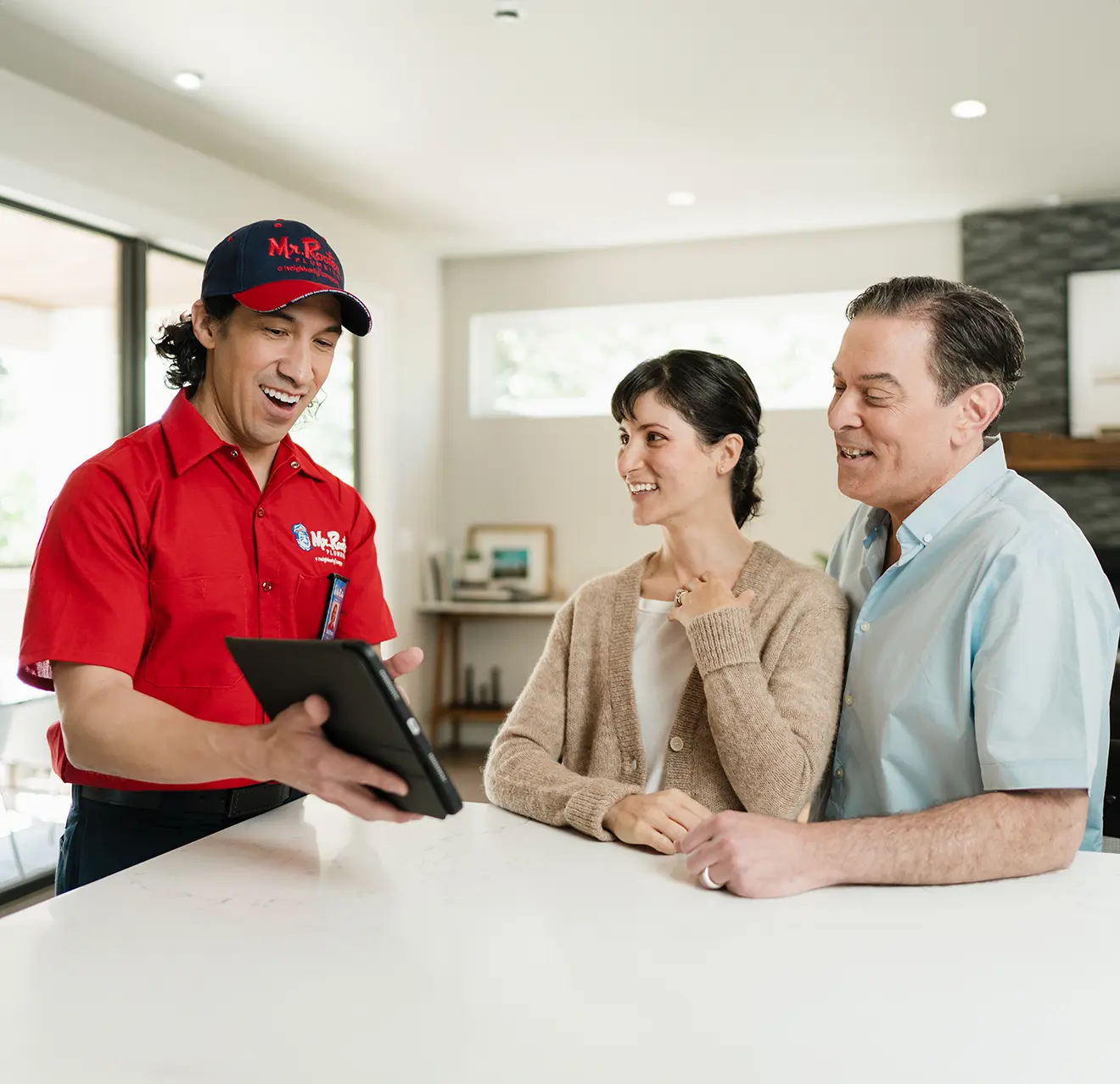 Mr. Rooter technician explaining a service to two customers.