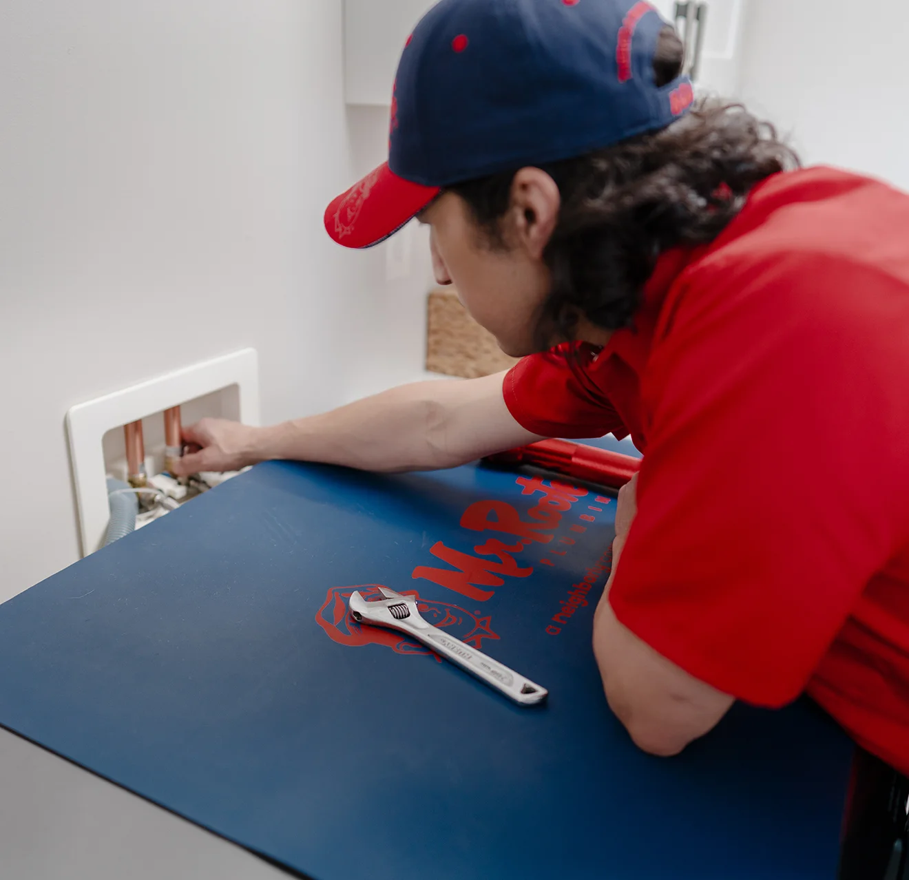 Mr. Rooter professional fixing a water valve.