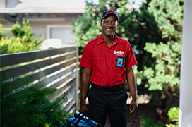 Mr. Rooter technician standing outside by a fence.