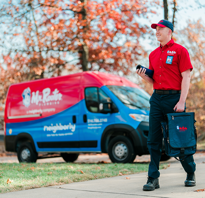 Mr. Rooter Plumbing professional with a branded van in the background.