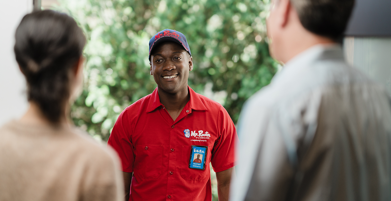 Smiling Mr. Rooter technician arriving at a customer's home.