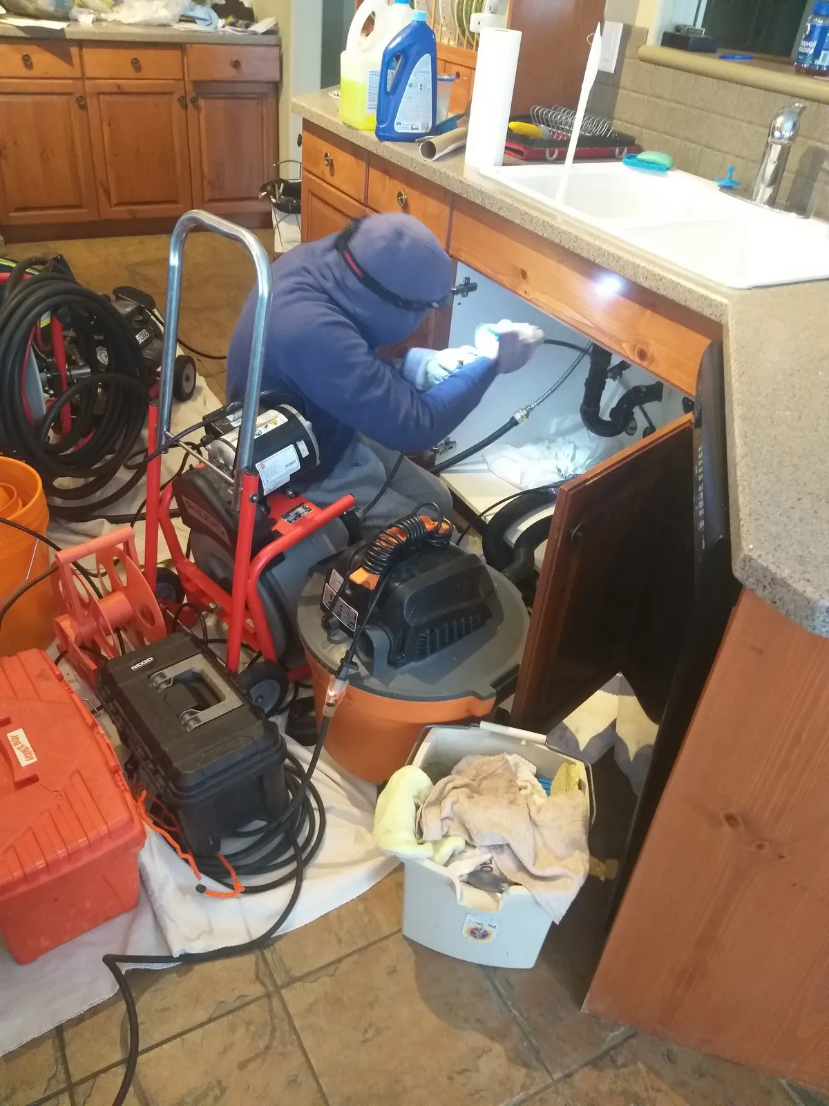 Mr. Rooter plumber using hydro scrub jetting to clear a clogged drain in Edmonton home.