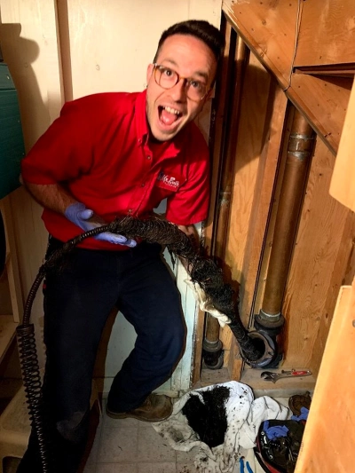 Mr. Rooter Plumbing technician showing freshly removed clog from St. Albert drain