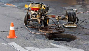 Plumbing equipment next to sewer hole for sewer cleaning in Edmonton.