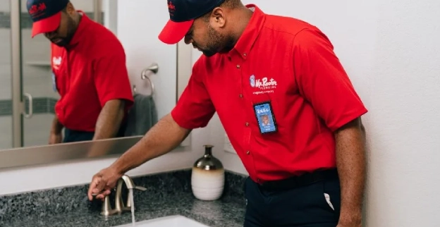 Mr. Rooter service professional runs water in sink after drain cleaning.