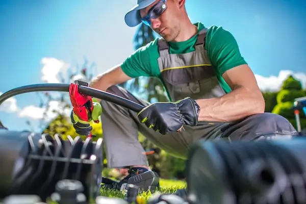 An irrigation system expert repairing an irrigation system water line. 